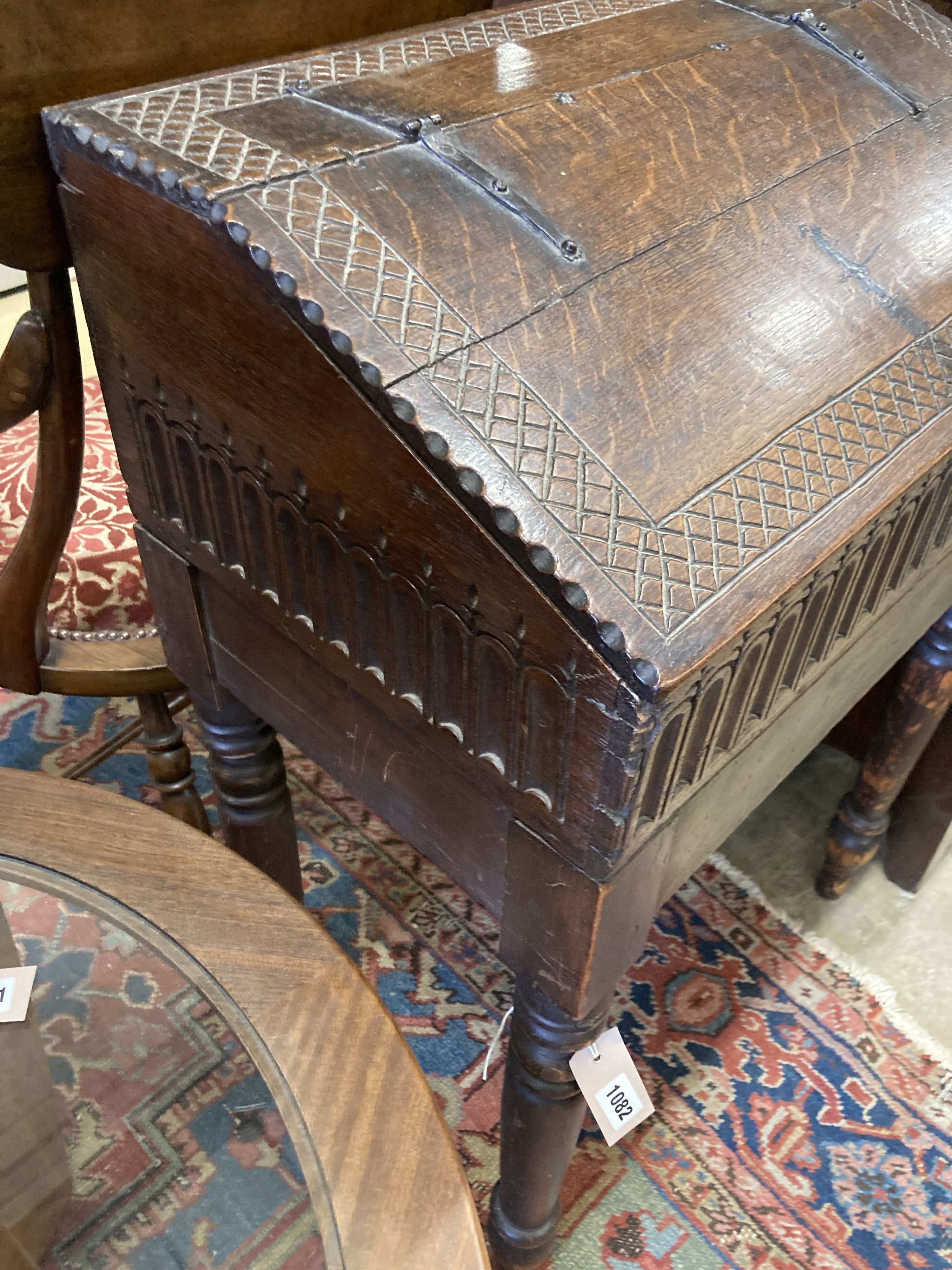 A 17th century oak slant front bible box, raised on a stand